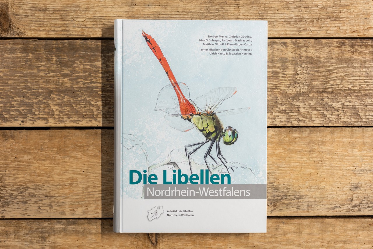 Das Buch "Die Libellen Nordrhein-Westfalens" auf einem Holztisch. Foto: LWL/Steinweg